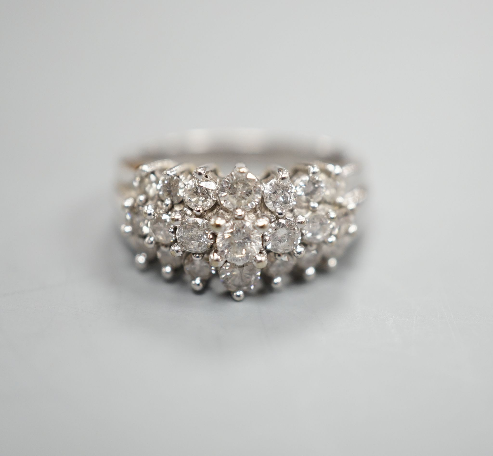 A modern 10k white metal and three row graduated diamond cluster set dress ring, size L, gross weight 4.3 grams.